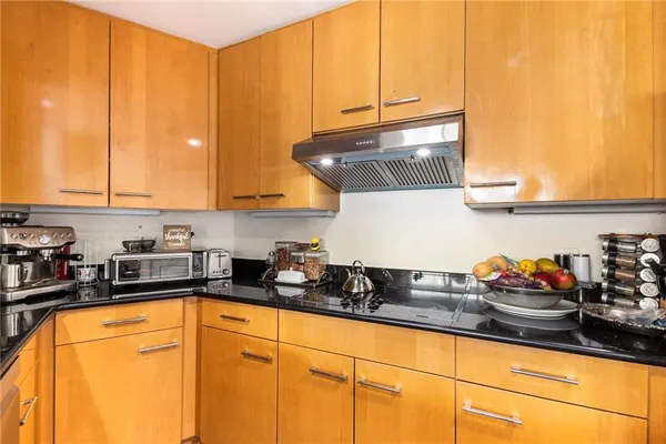 a kitchen with stainless steel appliances granite countertop a sink a stove and cabinets