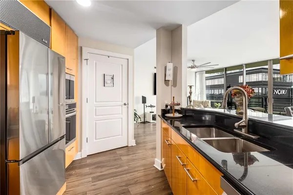 a kitchen with stainless steel appliances granite countertop a sink and a refrigerator