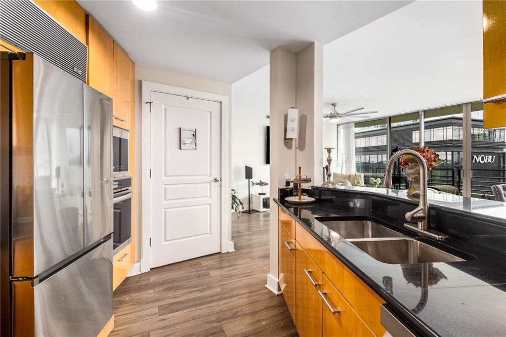 700 Park Regency Place Northeast, Unit 1603 Atlanta, GA 30326 - Photo 14 of 25 a kitchen with stainless steel appliances granite countertop a sink and a refrigerator