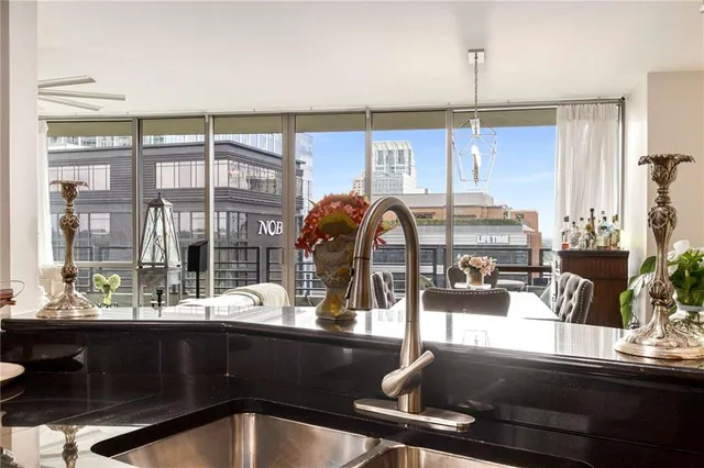 a kitchen with a sink and living room view