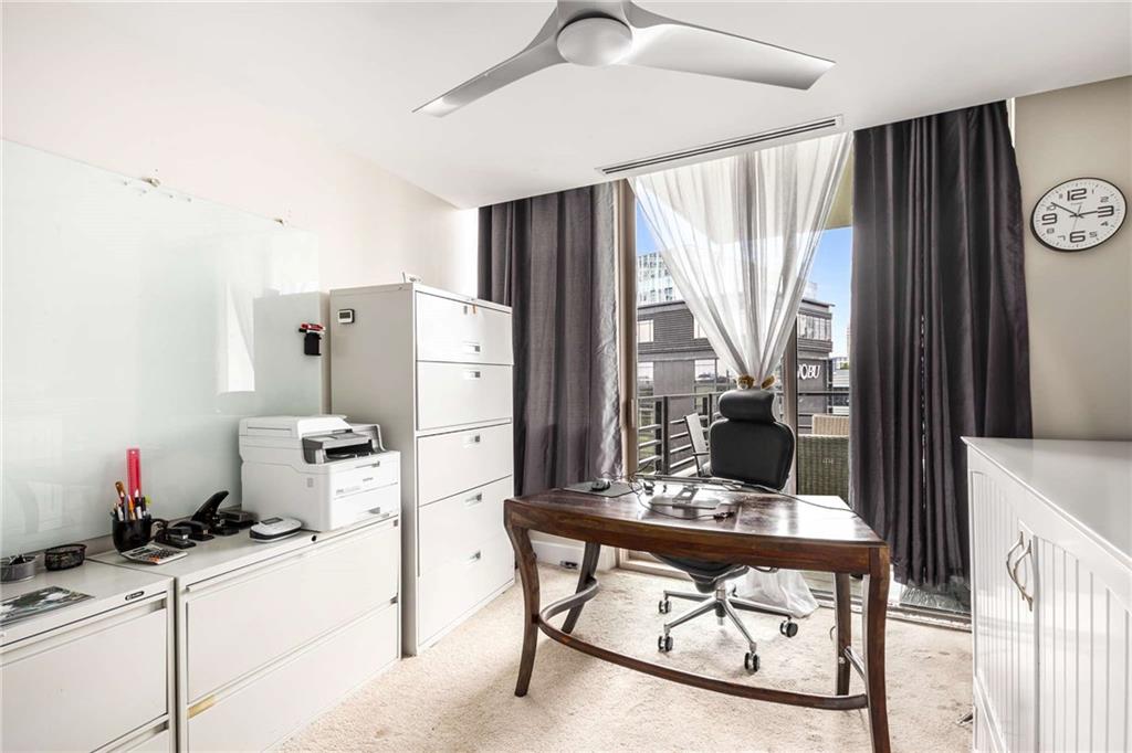 700 Park Regency Place Northeast, Unit 1603 Atlanta, GA 30326 - Photo 16 of 25 a kitchen with stainless steel appliances kitchen island granite countertop a table chairs and a refrigerator