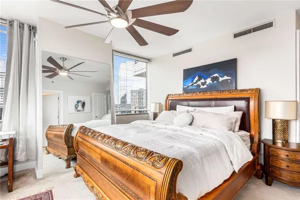 a bedroom with a bed and a painting on the wall