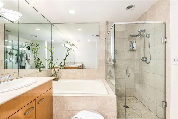 a bathroom with a granite countertop sink a toilet and shower