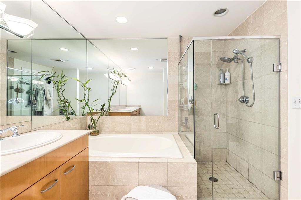 700 Park Regency Place Northeast, Unit 1603 Atlanta, GA 30326 - Photo 18 of 25 a bathroom with a granite countertop sink a toilet and shower