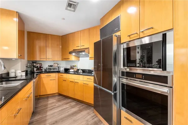 a kitchen with stainless steel appliances kitchen island granite countertop a stove a refrigerator and a microwave