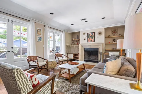 a living room with furniture fireplace and a large window