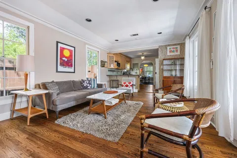 a living room with furniture and a wooden floor