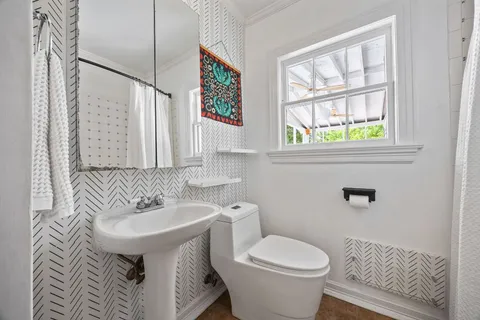 a bathroom with a sink toilet and a mirror