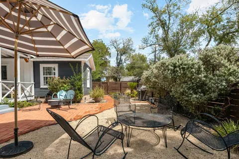 a view of a patio with table and chairs and potted plants with wooden floor and fence