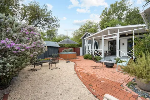 a view of a patio with table and chairs potted plants and large tree