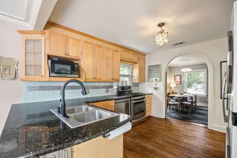 a kitchen that has stainless steel appliances granite countertop a sink stove and refrigerator