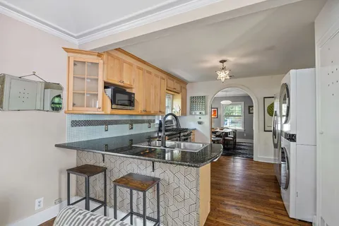 a kitchen with sink refrigerator dining table and chairs