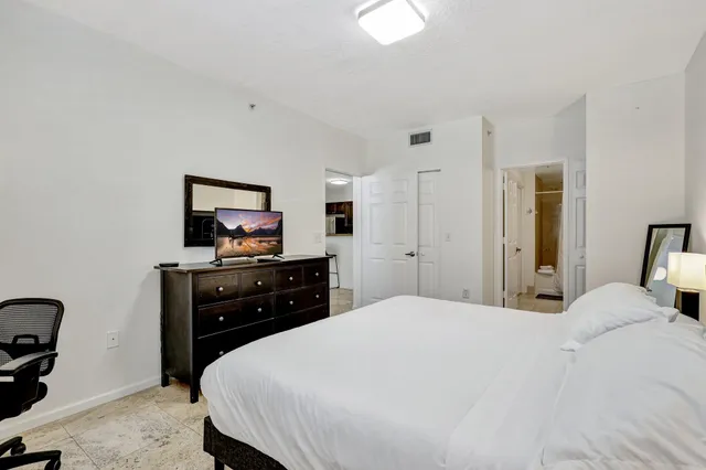 a bedroom with a bed and a flat screen tv