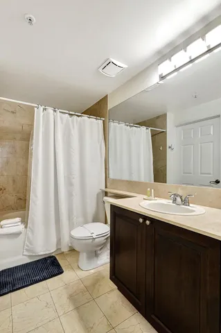 a bathroom with a double vanity sink toilet and a mirror