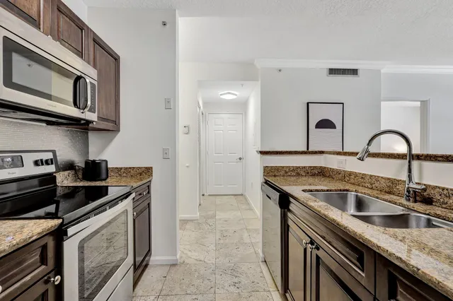 a kitchen with stainless steel appliances granite countertop a sink stove and cabinets
