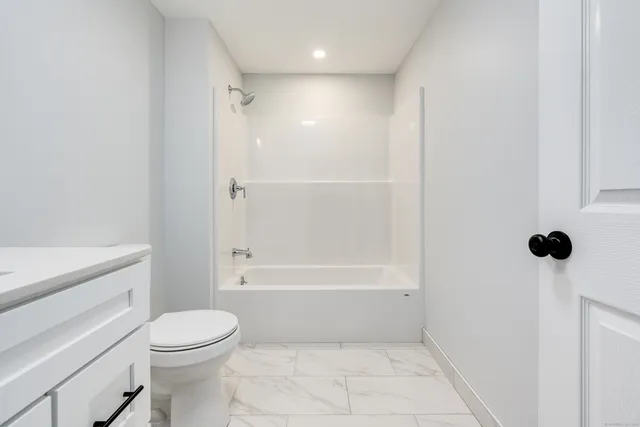 a bathroom with a shower a toilet and a tub