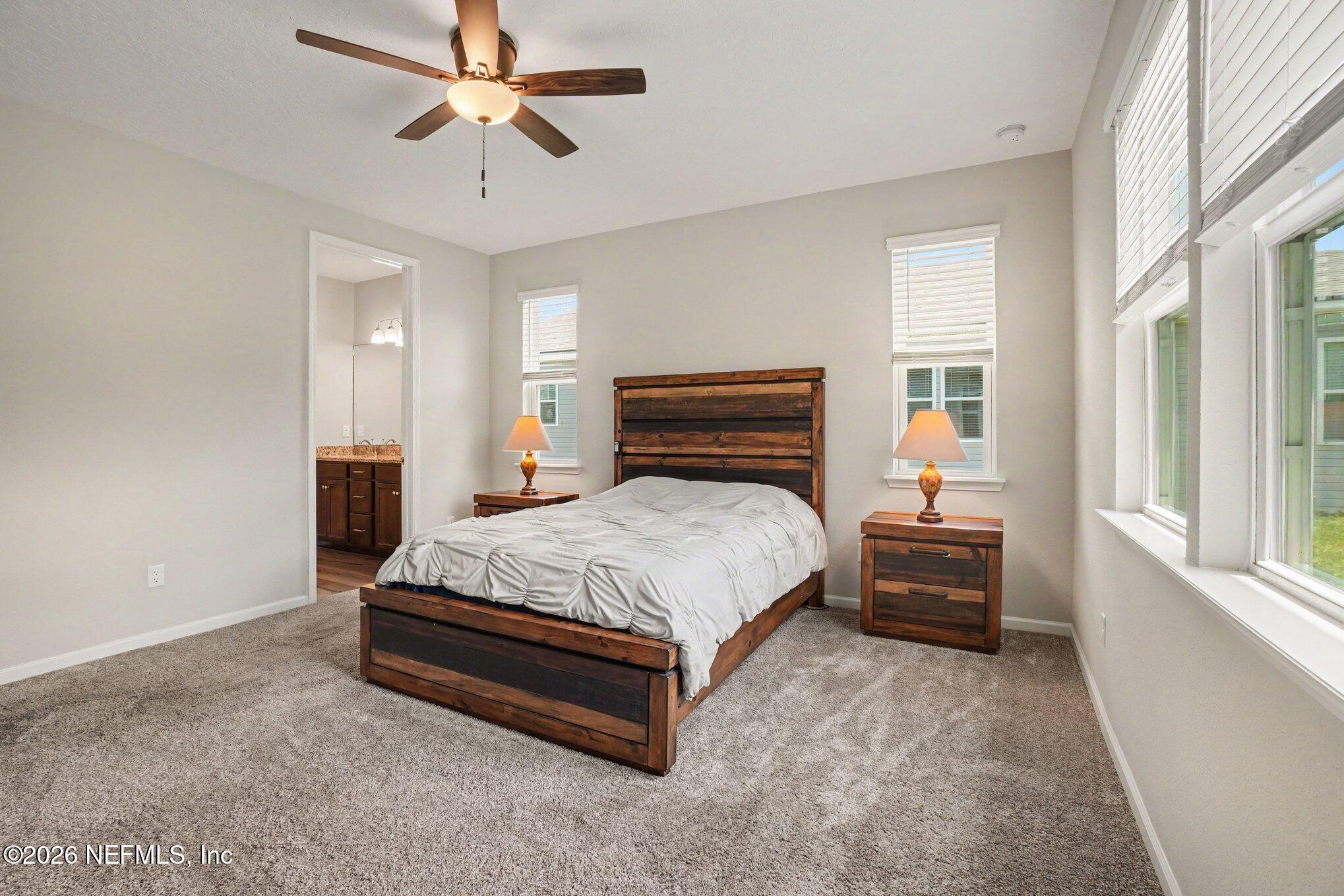 4630 Pine Ridge Parkway Middleburg, FL 32068 - Photo 15 of 35 a bed sitting in a bedroom next to a window with a chandelier