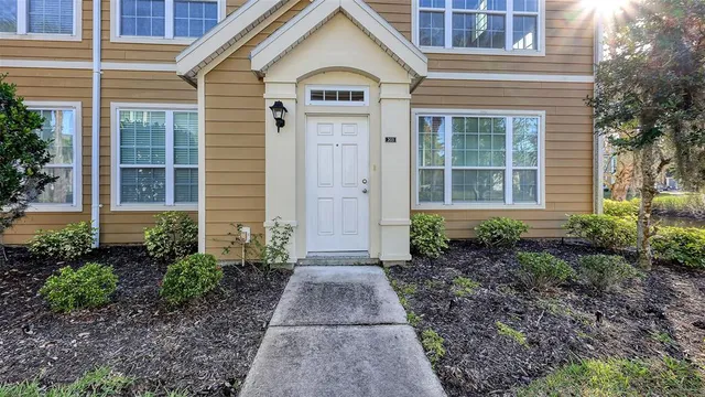 a view of a brick house with yard and plants