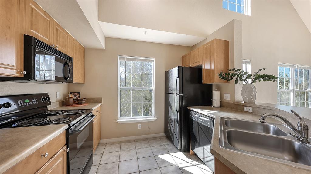 5520 Rosehill Road, Unit 203 Sarasota, FL 34233 - Photo 12 of 46 a kitchen with stainless steel appliances granite countertop a sink stove and refrigerator