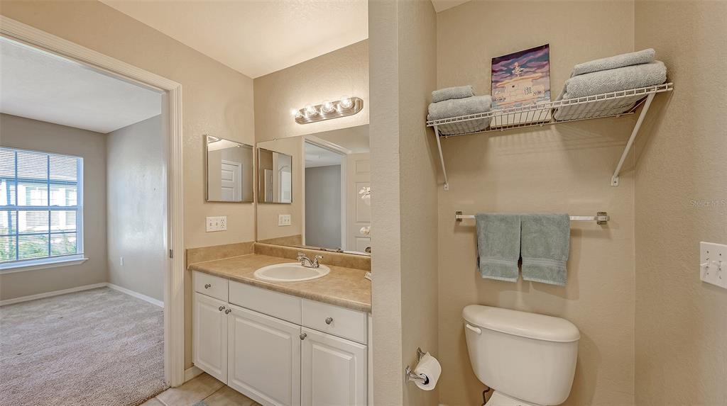 5520 Rosehill Road, Unit 203 Sarasota, FL 34233 - Photo 20 of 46 a spacious bathroom with a granite countertop toilet a sink and a mirror
