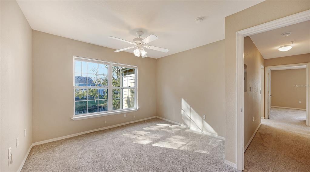 5520 Rosehill Road, Unit 203 Sarasota, FL 34233 - Photo 22 of 46 an empty room with chandelier fan and windows