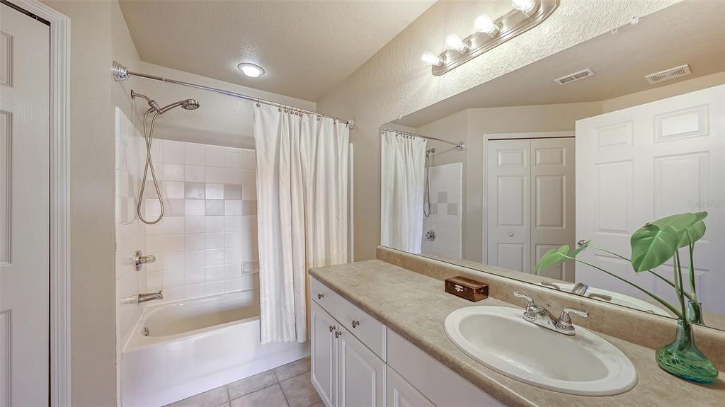 5520 Rosehill Road, Unit 203 Sarasota, FL 34233 - Photo 26 of 46 a bathroom with a granite countertop sink a mirror a glass door a shower and a bathtub