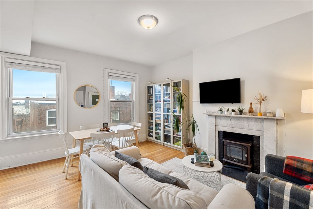 62 West Cedar Street, Unit 3 Boston, MA 02114 - Photo 1 of 18 a living room with furniture a fireplace and a flat screen tv