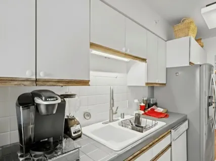 a kitchen with a sink stove and white cabinets