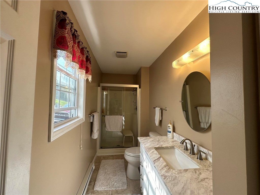 4952 Nile Road Sparta, NC 28675 - Photo 21 of 36 a en suite bathroom with a granite countertop toilet a sink and a large mirror