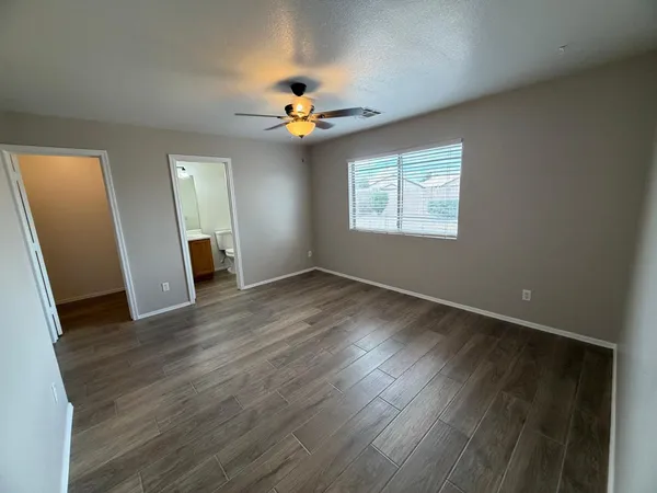 an empty room with wooden floor and gate