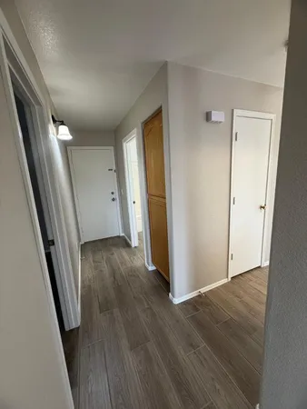 a view of a hallway with wooden floor and staircase
