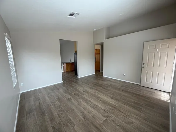 a view of a kitchen with wooden floor and electronic appliances