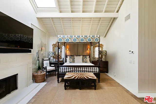 a bedroom with a bed chair and fireplace