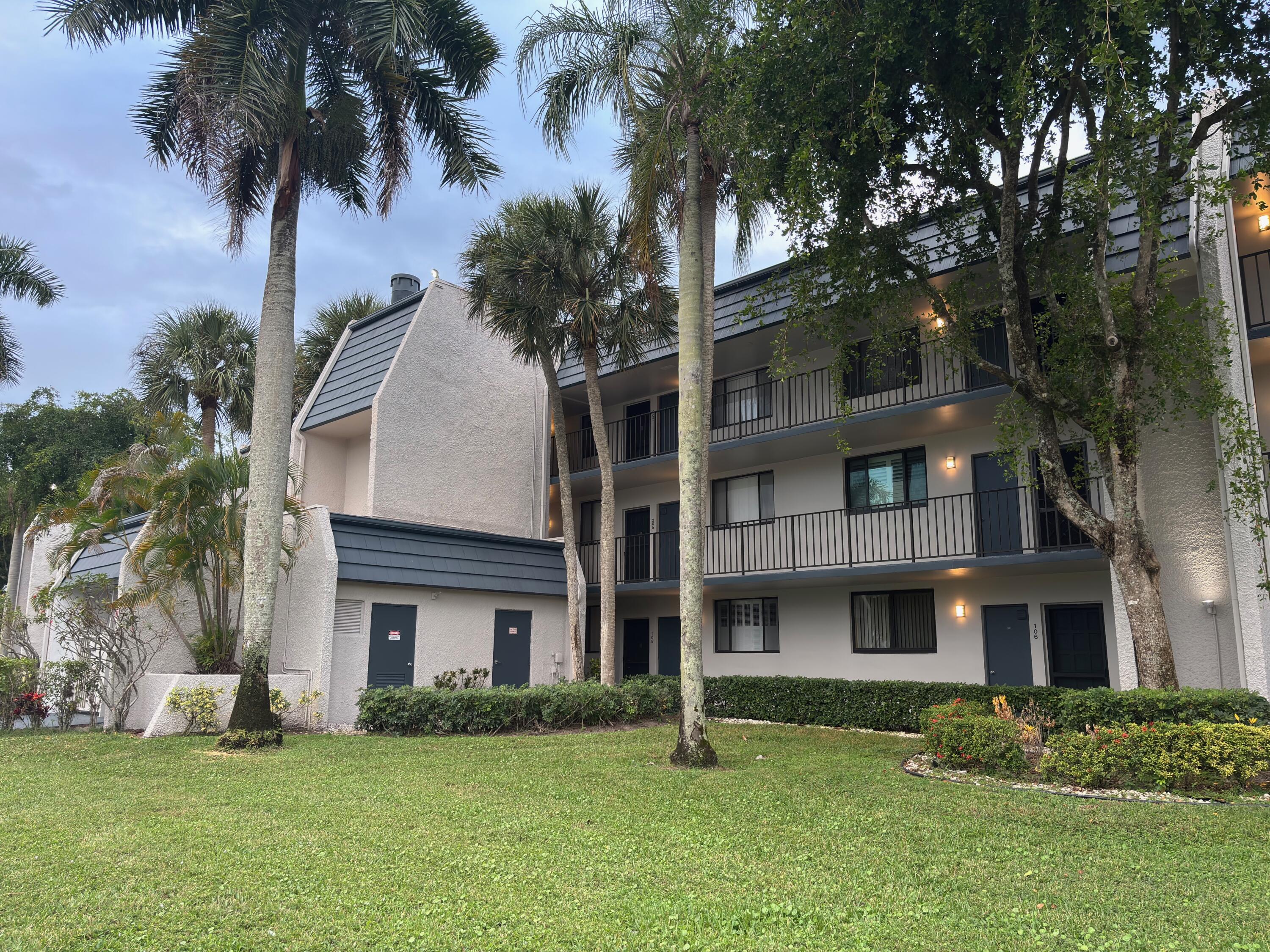 4411 Trevi Court, Unit 106 Lake Worth, FL 33467 - Photo 20 of 21 a front view of a house with a garden