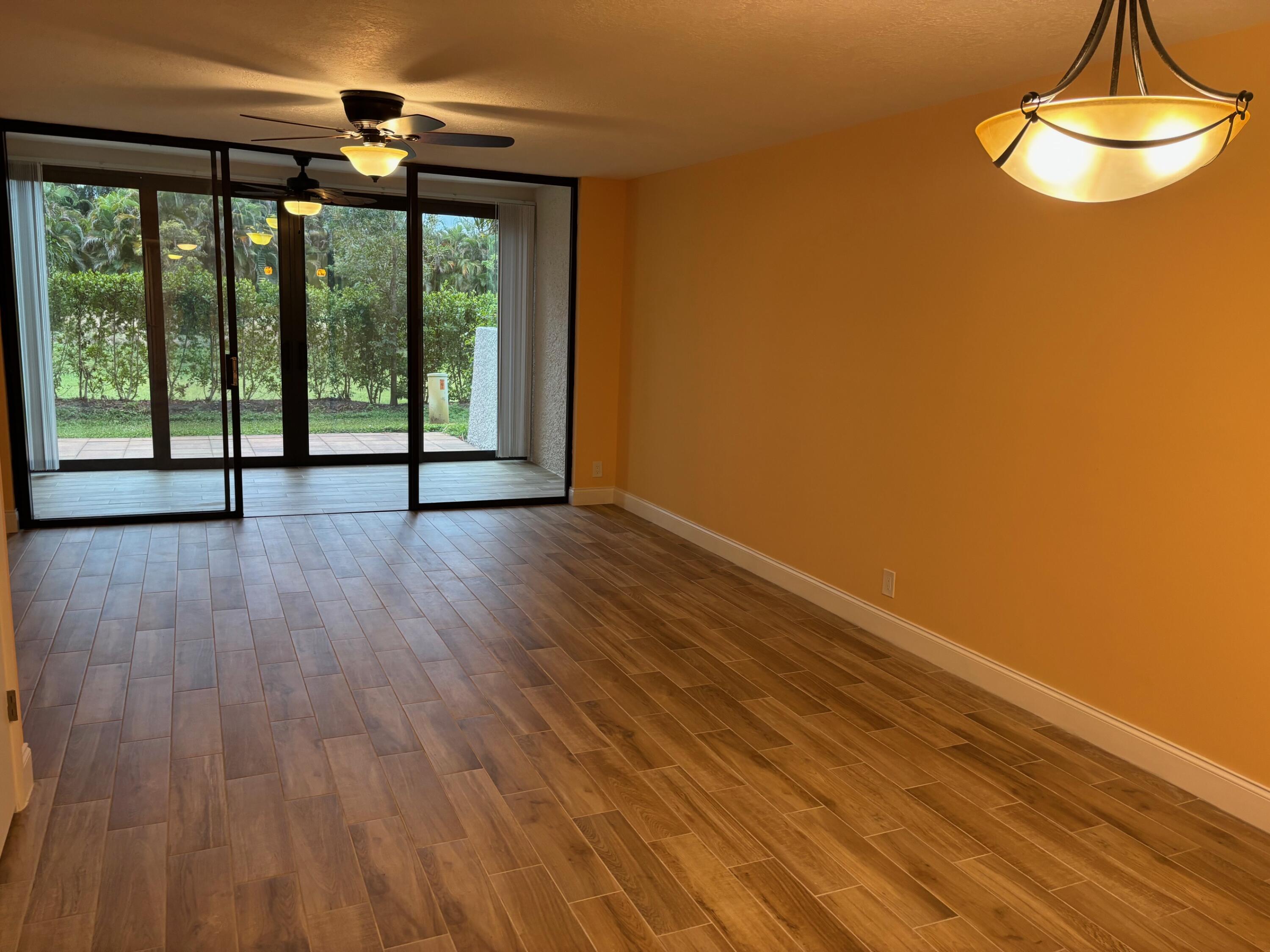 4411 Trevi Court, Unit 106 Lake Worth, FL 33467 - Photo 5 of 21 a view of an empty room with wooden floor and a window