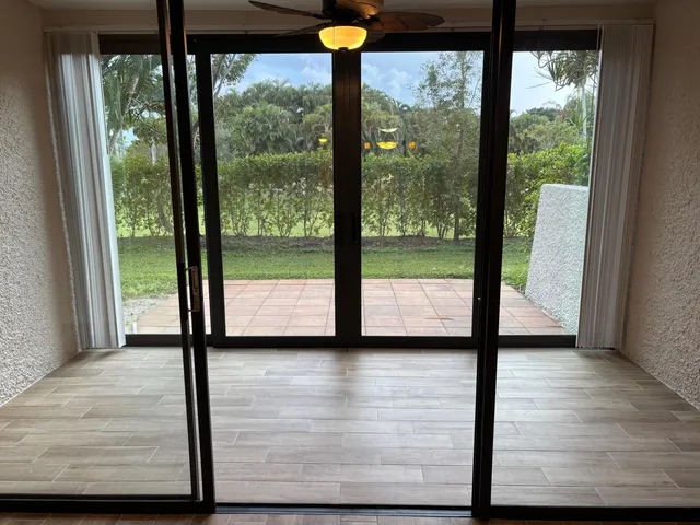 a view of hallway with a floor to ceiling window and wooden floor