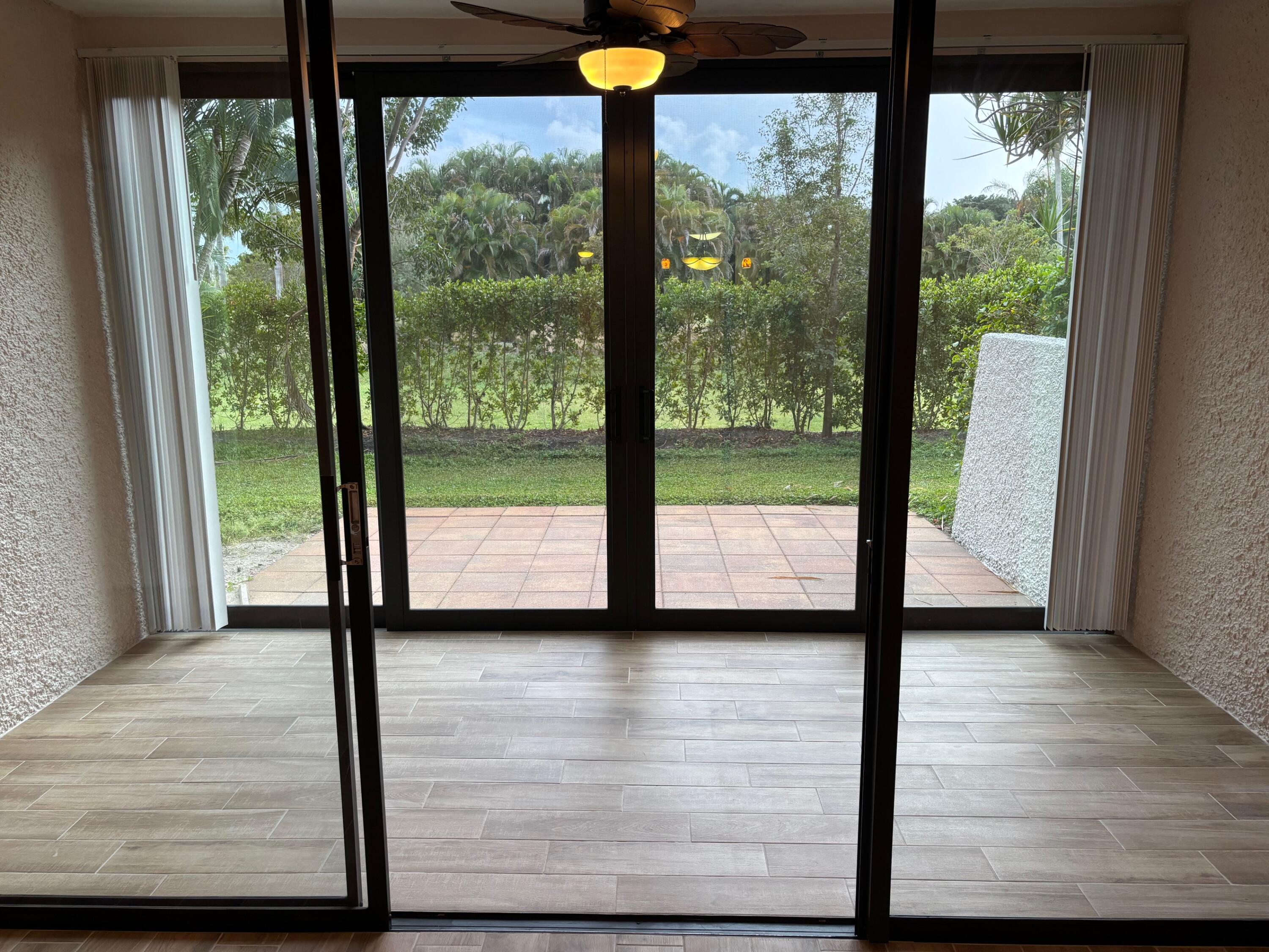 4411 Trevi Court, Unit 106 Lake Worth, FL 33467 - Photo 6 of 21 a view of hallway with a floor to ceiling window and wooden floor