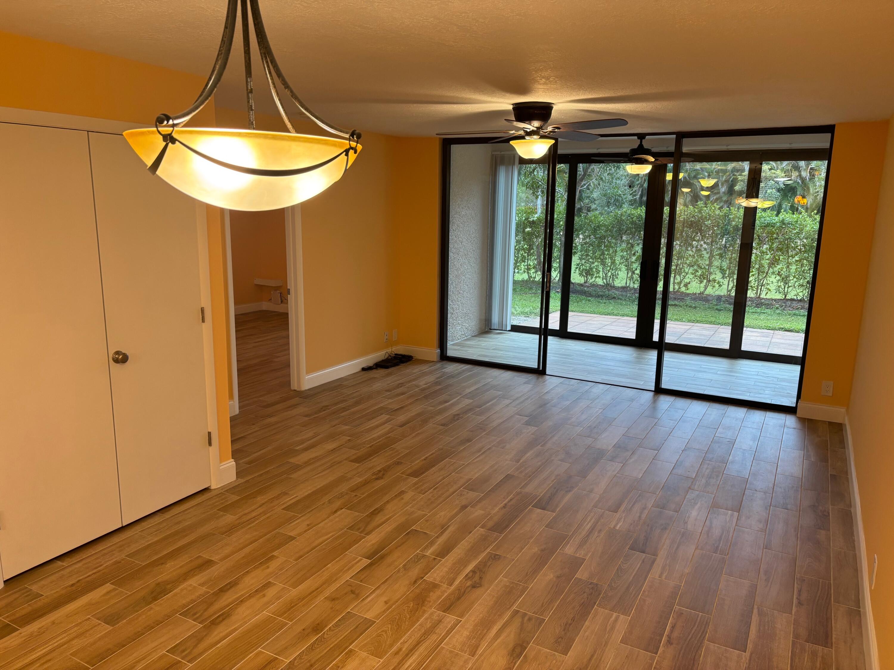 4411 Trevi Court, Unit 106 Lake Worth, FL 33467 - Photo 7 of 21 an empty room with wooden floor and windows