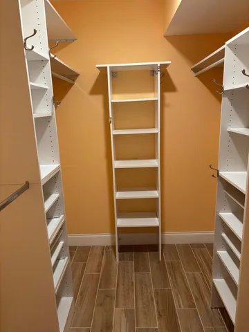 a view of walk in closet with empty racks