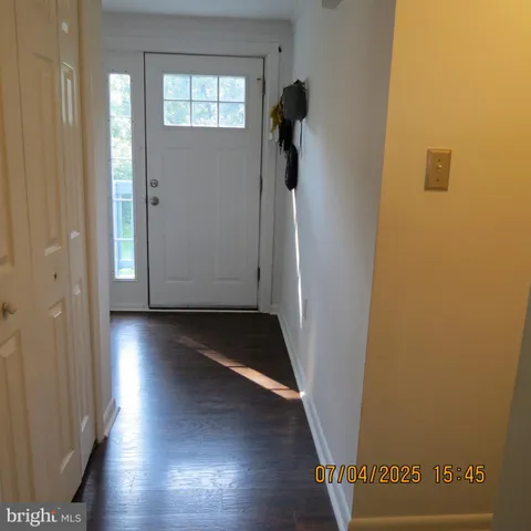an empty room with wooden floor and closet area