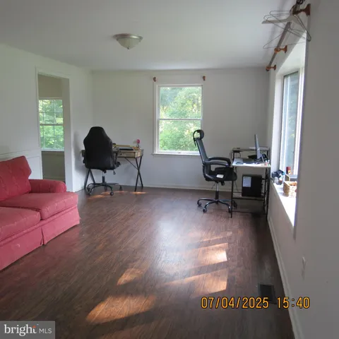 a view of a livingroom with workspace and a window