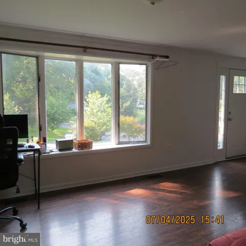 a kitchen with granite countertop white cabinets and wooden floor