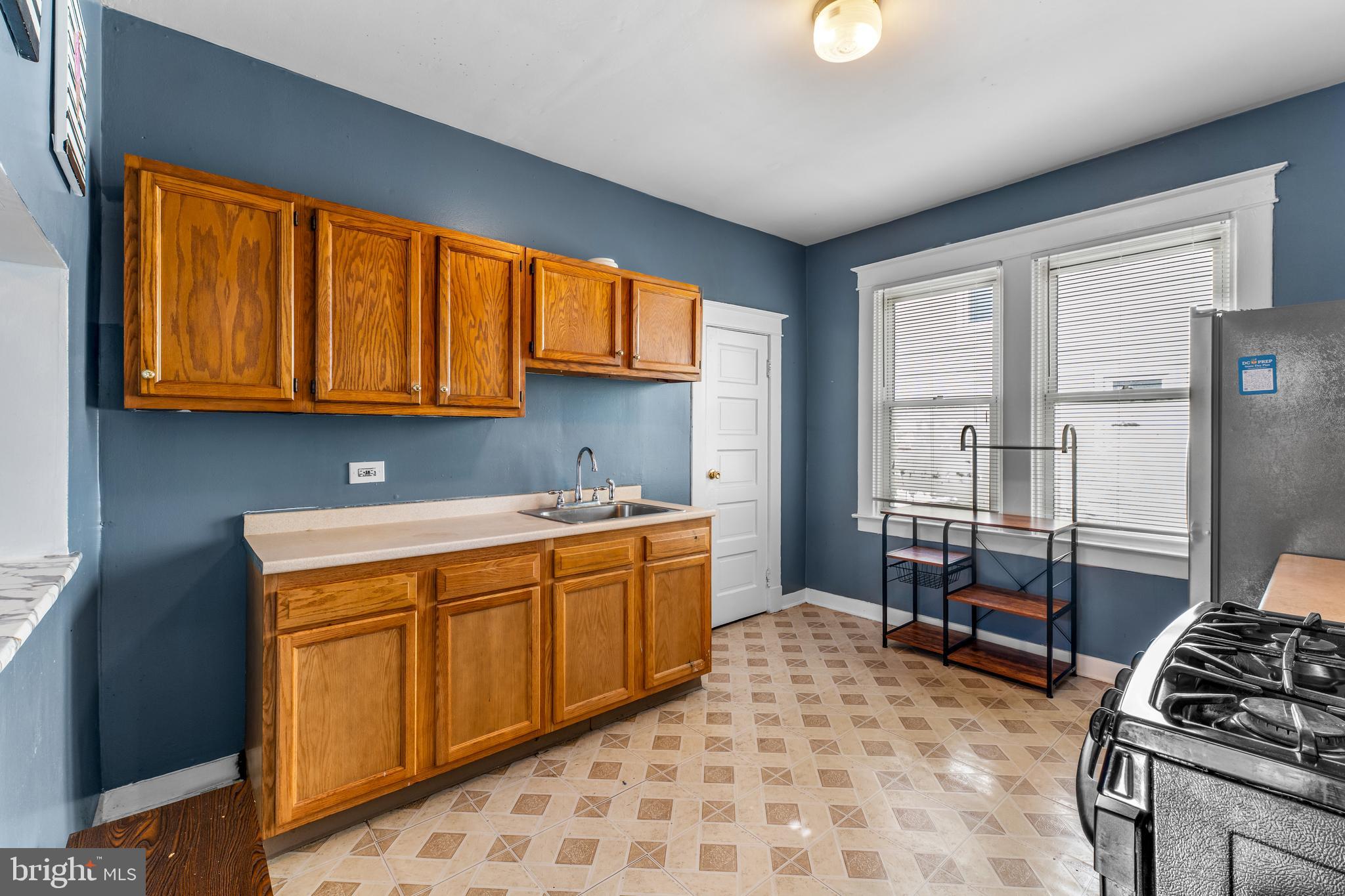 608 Tunbridge Road Baltimore, MD 21212 - Photo 12 of 27 a kitchen with a stove a sink and a refrigerator