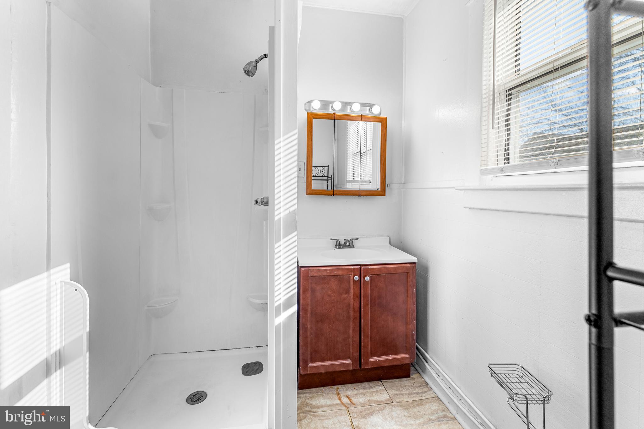 608 Tunbridge Road Baltimore, MD 21212 - Photo 21 of 27 a bathroom with a sink a window and shower