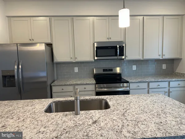 a kitchen with granite countertop a sink and a stove