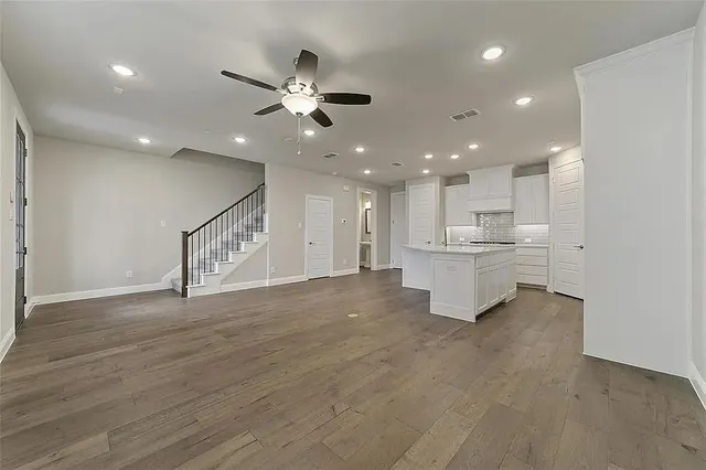 an empty room with ceiling fan and window