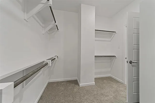 an empty room with ceiling fan and window