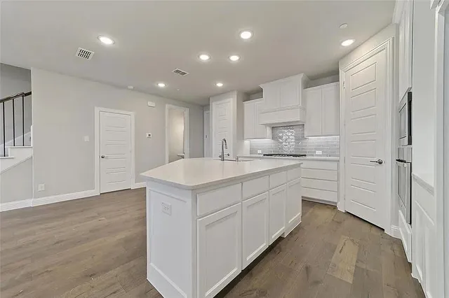 a kitchen with granite countertop stainless steel appliances and wooden cabinets