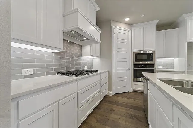 a large kitchen with kitchen island a sink appliances and a large window