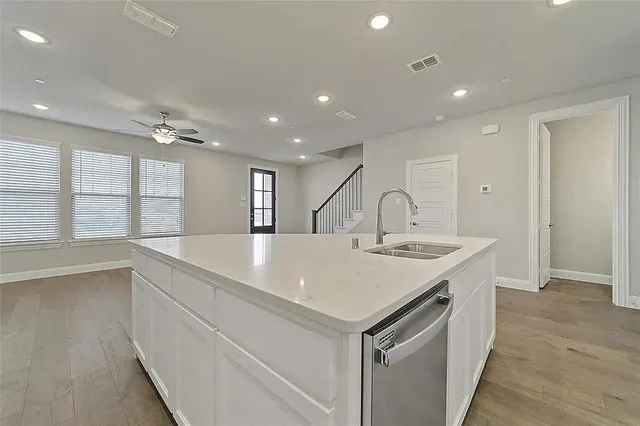 a living room with stainless steel appliances wooden floor and a fireplace
